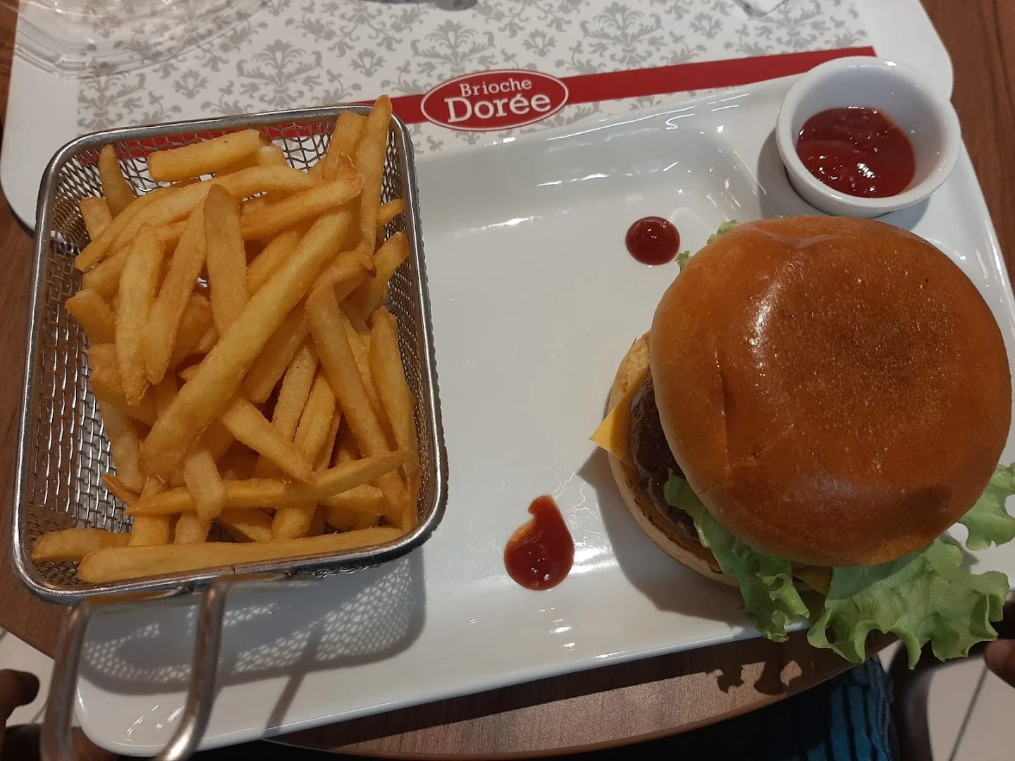 Brioche Dorée Arue, cheeseburger maison dans un pain brioché avec salade et frites maison en panier